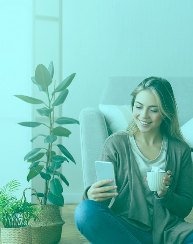 Girl using phone and holding the cup