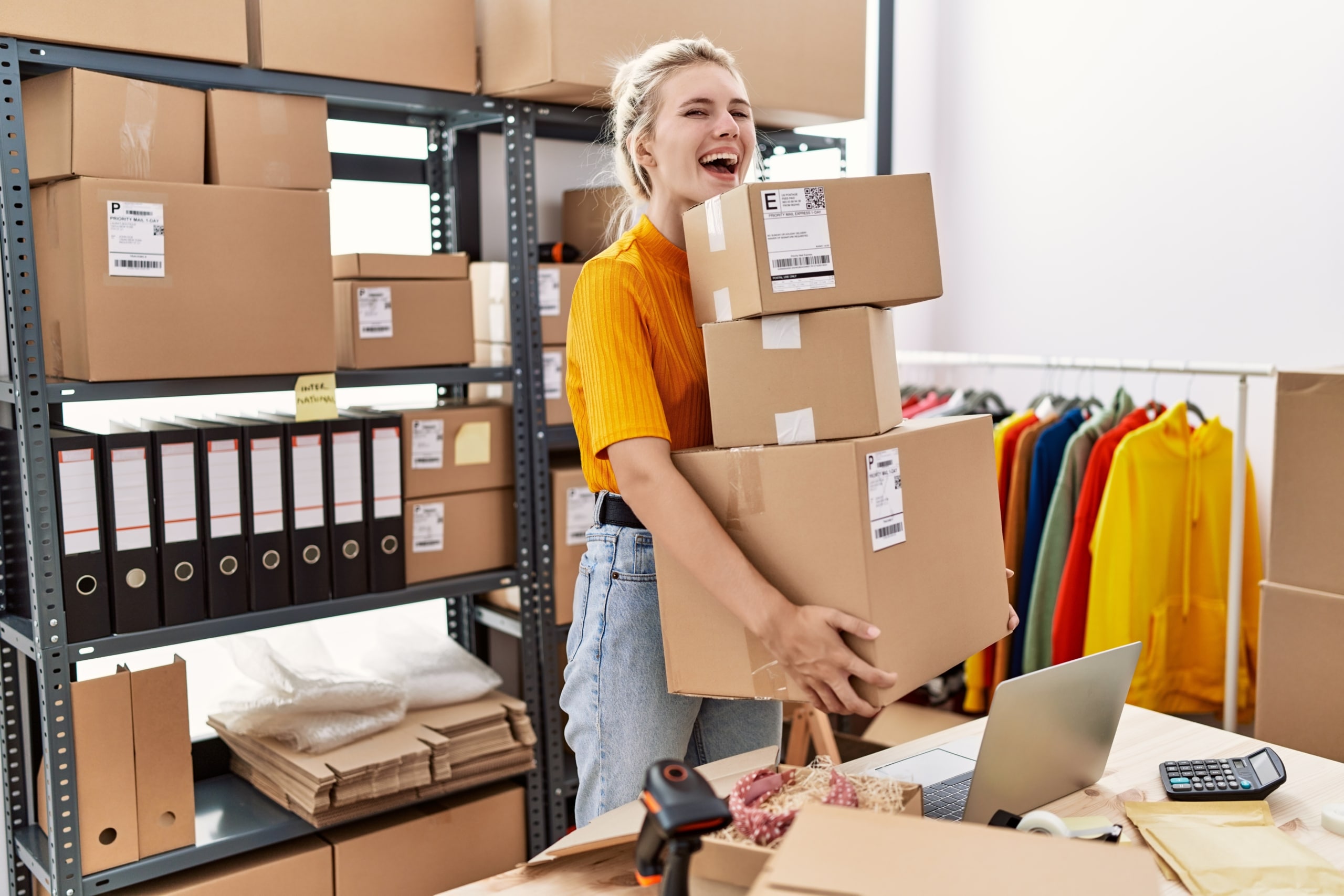 Young blonde woman working at small business ecommerce celebrating crazy and amazed for success with open eyes screaming excited