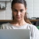 Horizontal photo mixed race female sitting on couch using computer