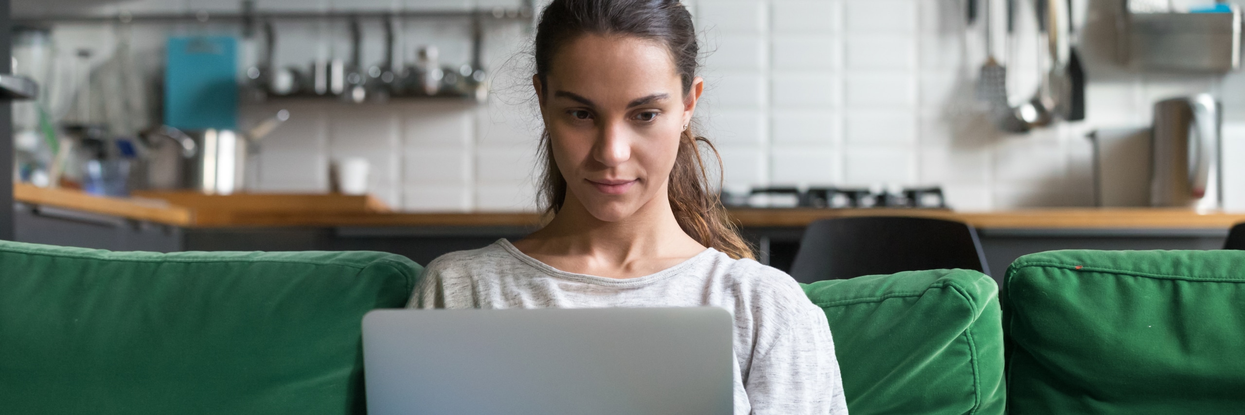 Horizontal photo mixed race female sitting on couch using computer