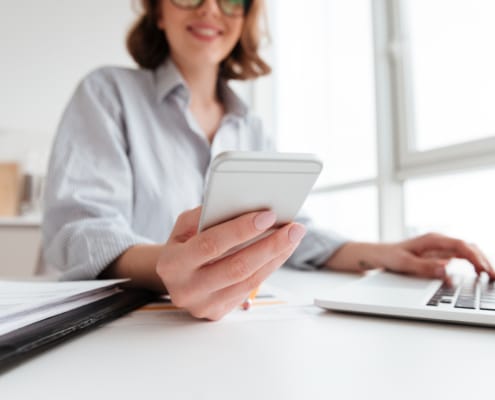 smiling young woman holding mobile phone