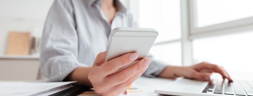 smiling young woman holding mobile phone