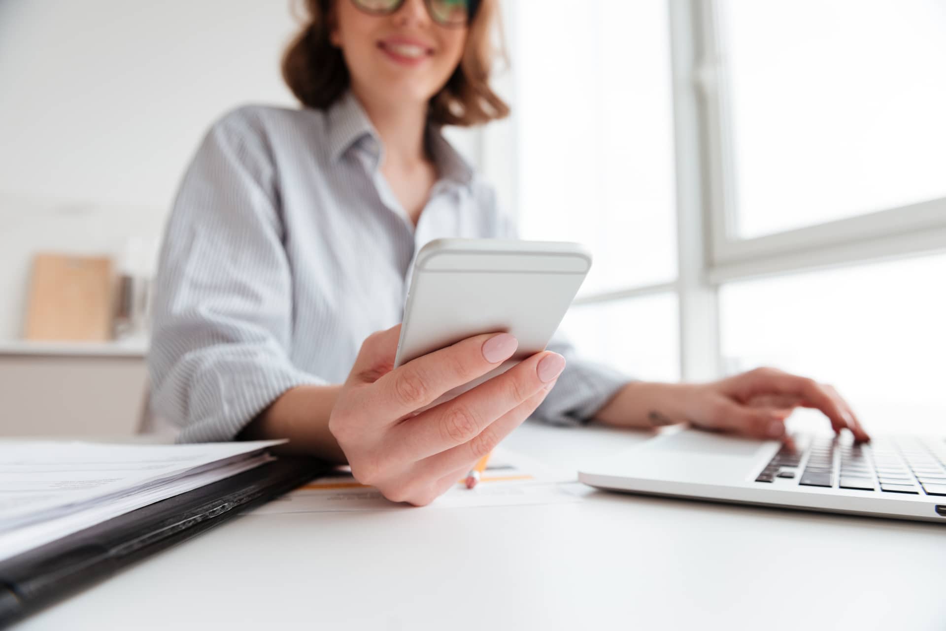 smiling young woman holding mobile phone